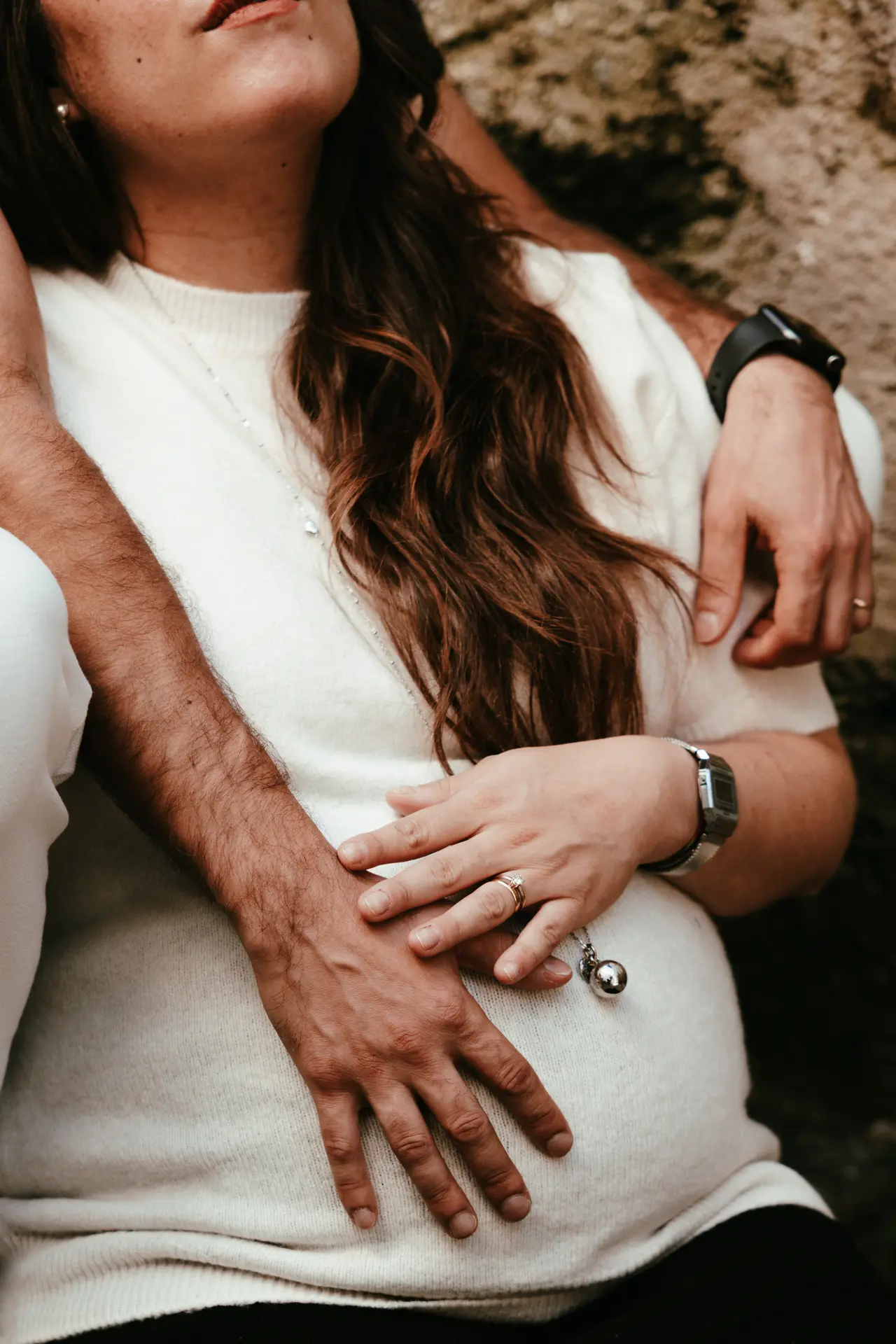 Dettaglio ravvicinato di mani che accarezzano il pancione, servizio fotografico maternità artistico di Sara Mellerio.