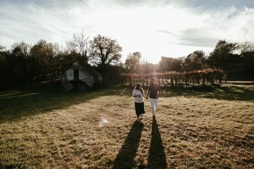 maternity-03-26-5 Coppia che cammina mano nella mano in un campo dorato, servizio fotografico di gravidanza all'aperto di Sara Mellerio.