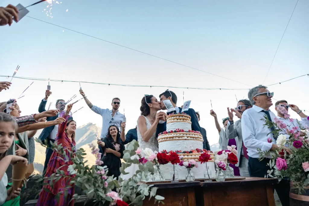 matrimoni-03-26-12 Bacio degli sposi al taglio della torta nuziale circondati da invitati con stelline luminose, scatto di Sara Mellerio.