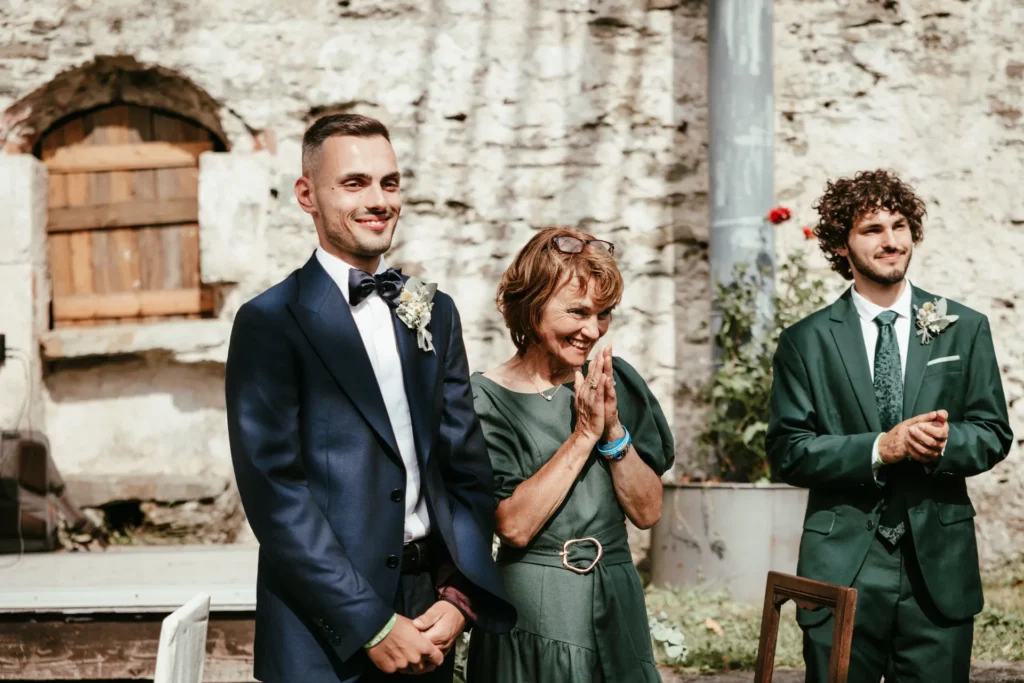 matrimoni-03-26-7 Ospiti sorridono durante la cerimonia all'aperto con testimoni e invitati, fotografia di matrimonio di Sara Mellerio.