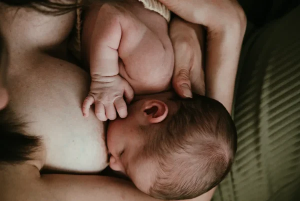 Primo piano del momento dell'allattamento tra madre e neonato – Fotografia newborn artistica di Sara Mellerio